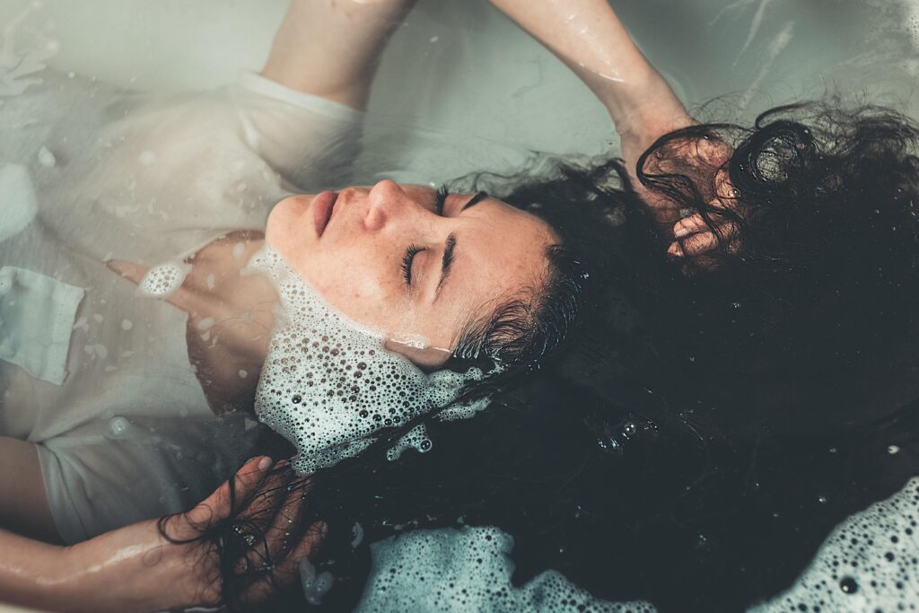 woman lying in bathtub filled with water 2306212