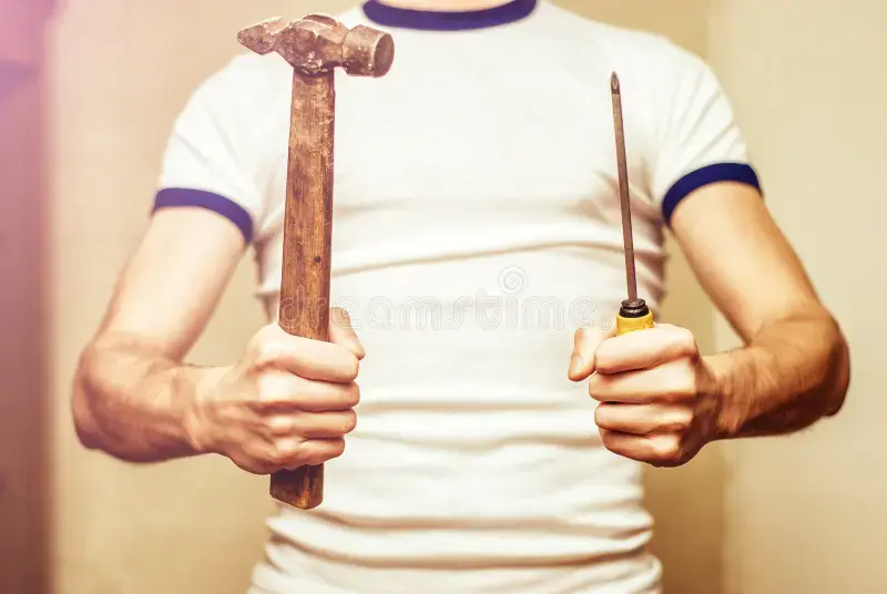 man holding vintage hammer screwdriver 86741223